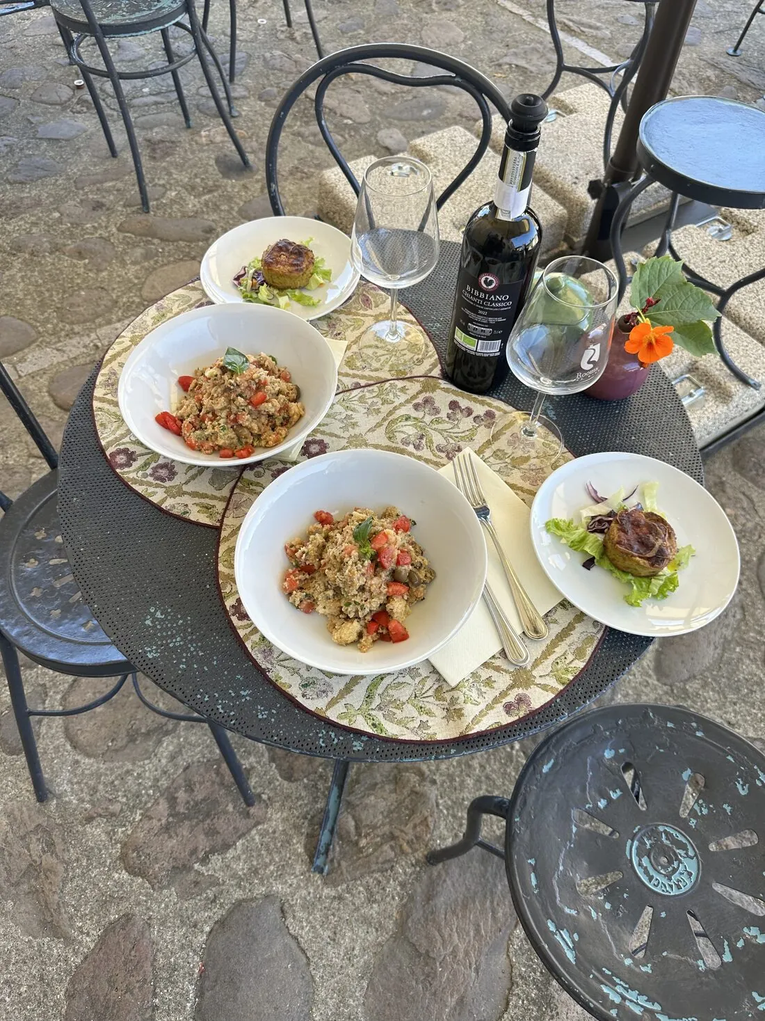 Piatti serviti sui tavoli in piazza, con una bottiglia dei nostri vini